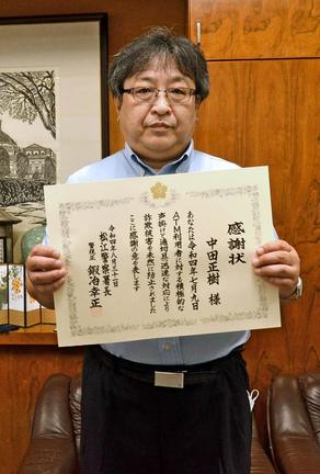 感謝状を手にする中田正樹さん＝松江市浜乃木８丁目、松江商業高校