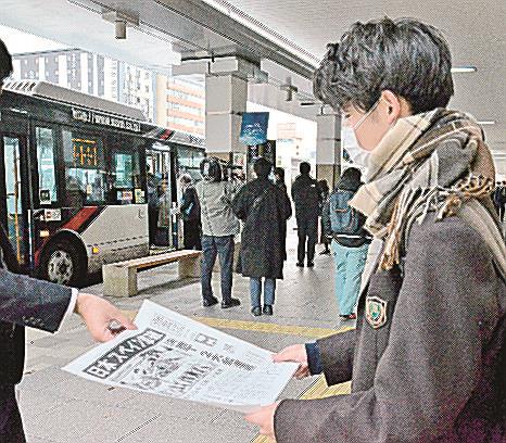 日本勝利を伝える号外を受け取る通行人＝松江市朝日町、ＪＲ松江駅前