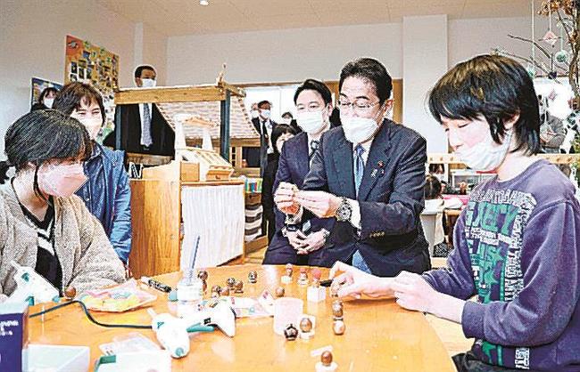 「異次元の少子化対策実施」に向け、子育て支援施設を視察し、子どもと工作を楽しむ岸田首相（右から２人目）。加速する少子化に歯止めをかけたい＝２月、岡山県奈義町（代表撮影）