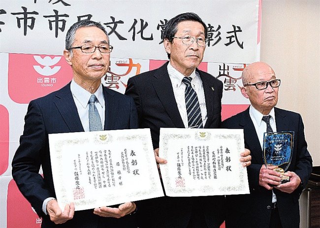 賞状を手にする原禎幸さん（左）と斐川町相撲連盟の原秀範会長（中央）＝出雲市今市町、市役所