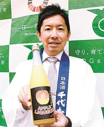 リンゴのリキュールを紹介する岡空聡氏＝鳥取県日南町霞、同町役場