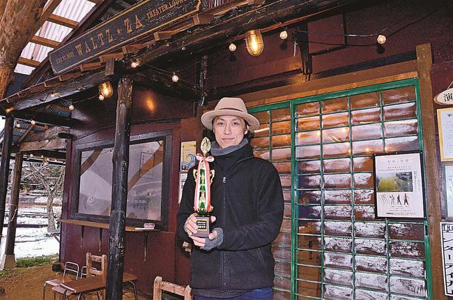 トロフィーを手に受賞を喜ぶ桑原宙さん＝津和野町長福、木部の杜ワルツ座