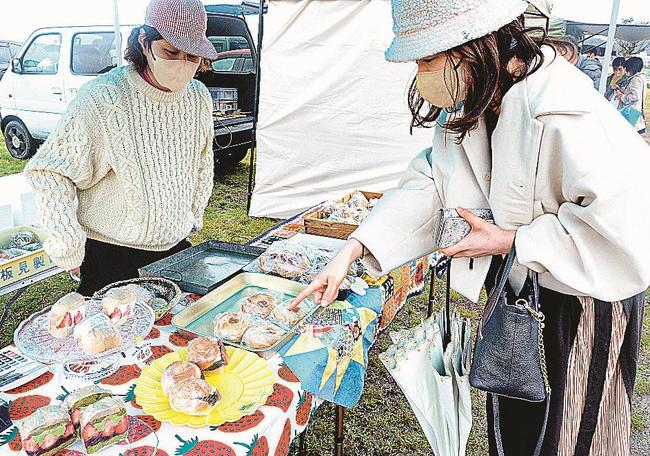 イチゴをはさんだ各種サンドイッチを品定めする来場者（右）＝安来市穂日島町、中海ふれあい公園