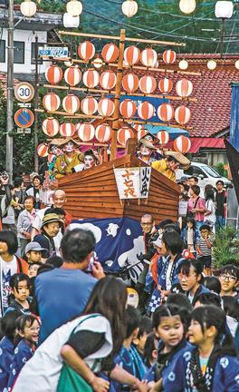 ちょうちんで飾られた巨大な舟を引く大勢の住民＝島根県邑南町矢上