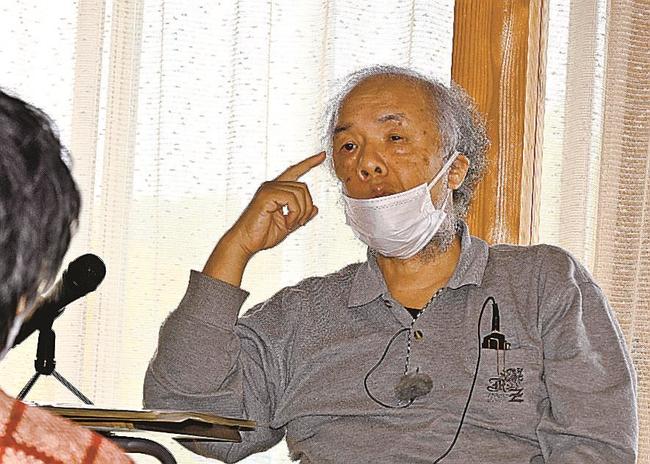 洞窟への思いや自身の経験を、手ぶりを使って話す門脇和也さん＝松江市八束町亀尻、亀尻集会所