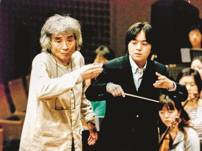 小澤征爾さん（左）から指揮の技術を教わる伊藤翔さん＝２００３年、京都市、京都コンサートホール（伊藤さん提供）