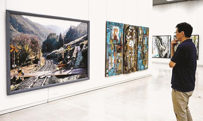 写実的な絵画を鑑賞する来場者＝松江市袖師町、島根県立美術館ギャラリー