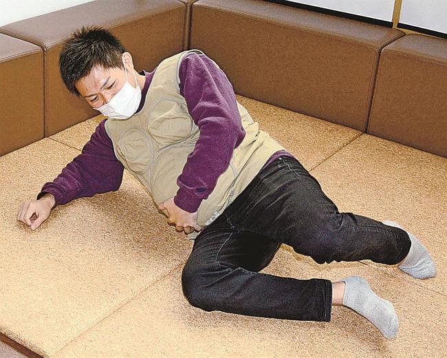 妊婦体験用のジャケットを来て、体の不自由さを実感する社員＝松江市西尾町、マツダオートザム松江