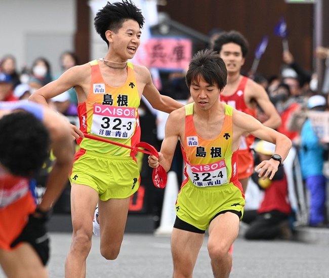 島根の３区伊藤蒼唯(左、駒大)からたすきを受けて走り出す４区野村渓達(益田東高)＝第３中継所