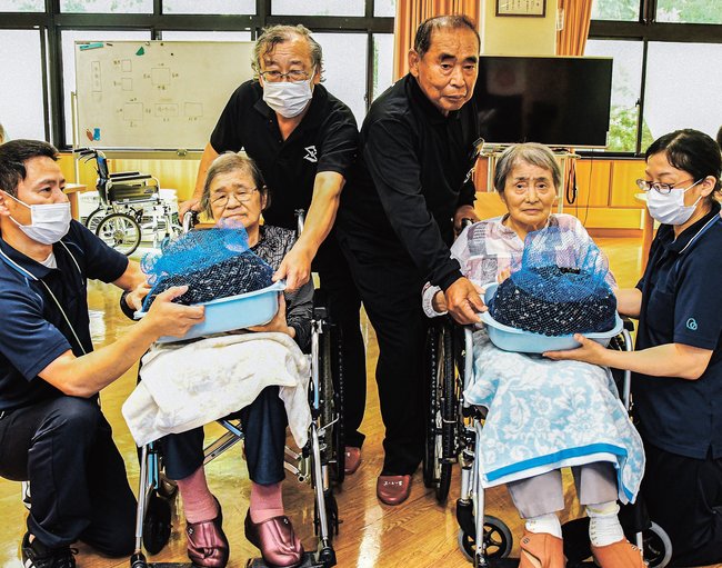 利用者にヤマトシジミを贈る渡部和夫組合長（右から３人目）ら＝松江市岡本町、介護老人福祉施設「あいかの里」