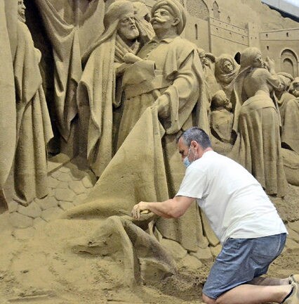 左官こてを使い慎重に作業する砂像彫刻家＝鳥取市福部町湯山、鳥取砂丘砂の美術館