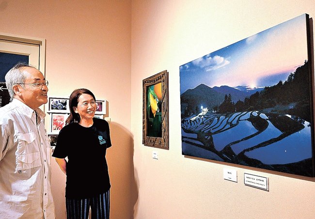 浜田市三隅町の棚田の夜景を捉えた作品（右）を鑑賞する来館者＝浜田市三隅町古市場、石正美術館
