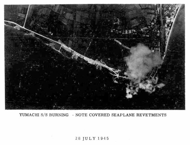 煙をあげる松江市玉湯町湯町の海軍飛行隊の水上偵察機基地の写真。煙右手に玉湯川、左手に並ぶ円形の施設は、偵察機の係留施設とみられる（国立国会図書館蔵）