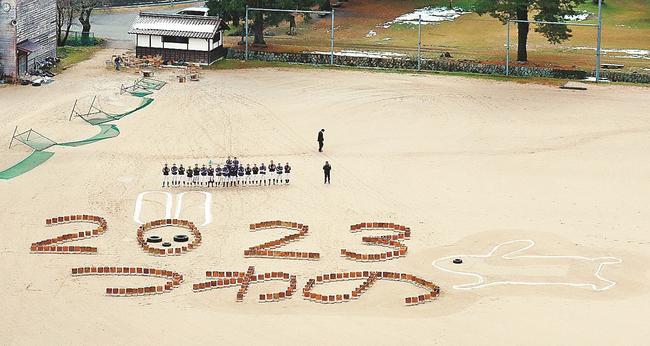 太皷谷稲成神社境内下のグラウンドに津和野高校野球部員が描いた「２０２３　つわの」の文字＝島根県津和野町後田