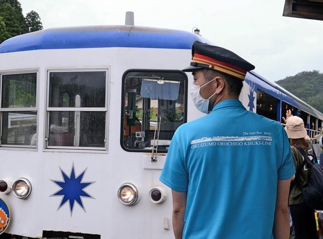 奥出雲おろち号がデザインされたポロシャツを着て業務に当たる木次鉄道部の小川修司部長＝島根県奥出雲町横田、出雲横田駅