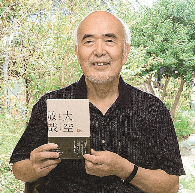 尾崎放哉を題材にした小説「大空放哉」を手にする足立悦男さん=境港市新屋町