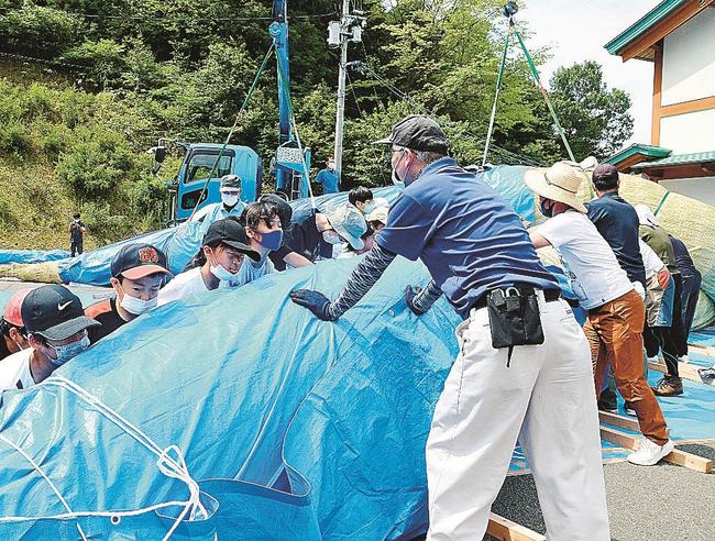 力を合わせて大縄をより合わせる参加者＝島根県飯南町花栗