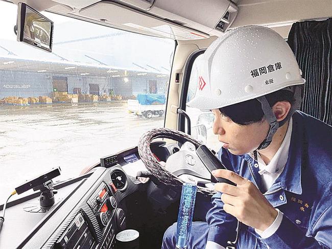 アルコール・インターロックを使って呼気検査する運転手（福岡倉庫提供）