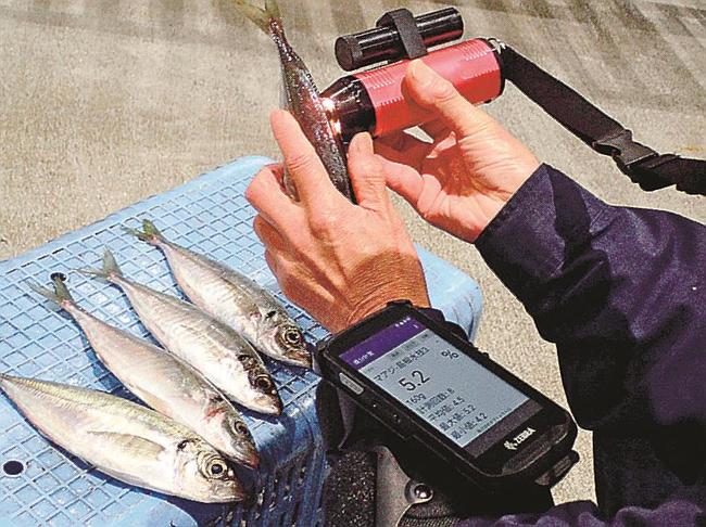 新しい脂質測定器を使う関係者（提供）