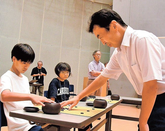 桑本晋平七段（右）の指導を受け、対局する参加者＝出雲市大社町杵築南、大社文化プレイスうらら館