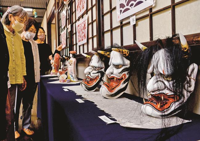 神楽面職人が手がけた般若面を鑑賞する来館者＝浜田市三隅町古市場、石州和紙会館