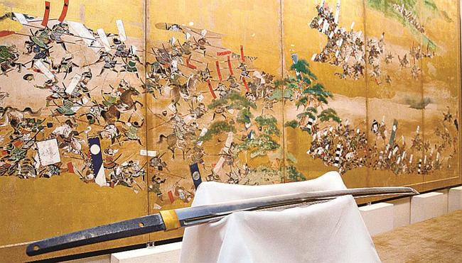 川中島合戦図屏風の前に展示された虎徹の刀＝出雲市浜町、出雲文化伝承館