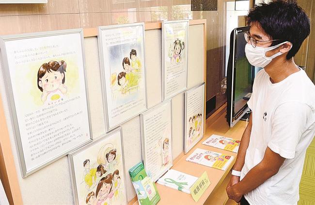 絵本「春ちゃんは元気です」のパネル展示に見入る来訪者＝松江市大輪町、島根県赤十字血液センター