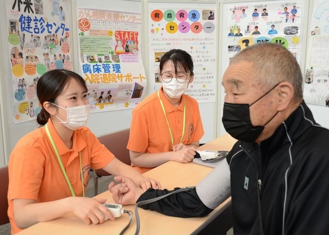 外来利用者の血圧を測定する看護師（左）＝浜田市浅井町、浜田医療センター