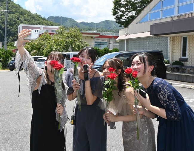 式典後に旧友と記念撮影をする参加者＝島根県吉賀町六日市、町六日市基幹集落センター前
