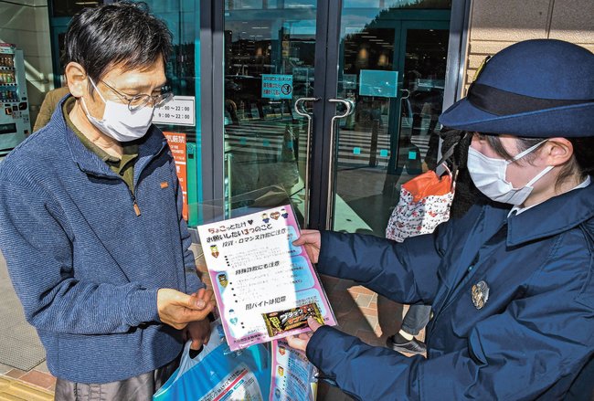 買い物客に詐欺被害防止の啓発チラシを配る大田署員(右)=大田市長久町、イオンタウン大田