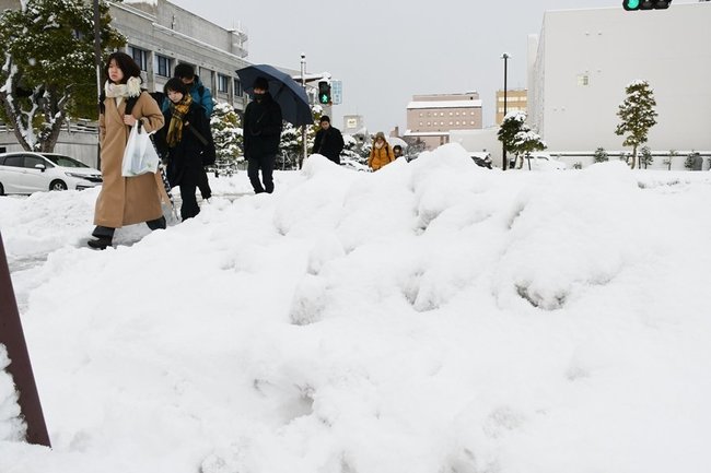 足元を気にしながら通勤する市民=25日午前8時25分、松江市殿町