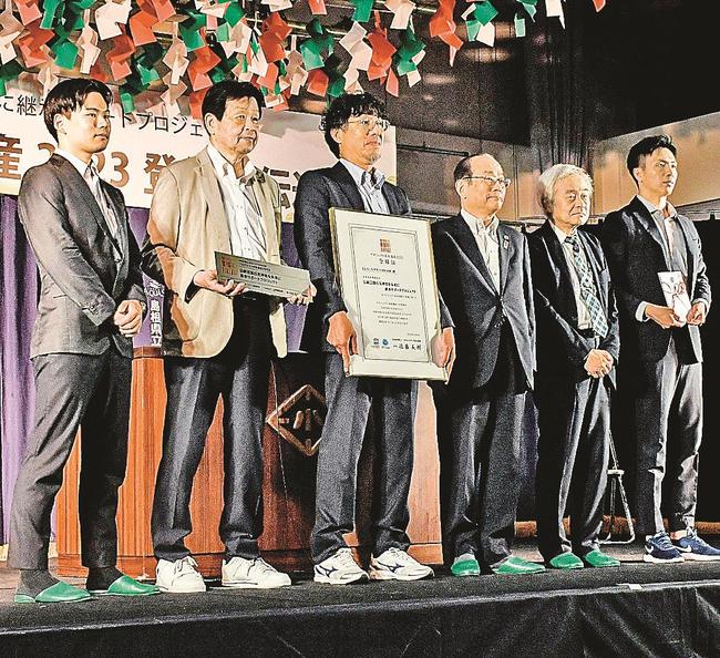 登録証を手に記念撮影する、半場徳一会長（左から３人目）ら関係者たち＝浜田市港町、原井小学校
