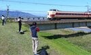国鉄色の特急やくもを撮影する鉄道ファン＝出雲市大津町、斐伊川