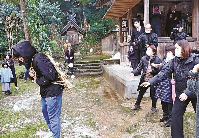 若者が背負った餅をめがけて雪玉を投げつける参加者＝松江市八雲町西岩坂秋吉、田村神社