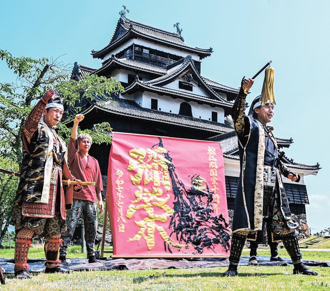 国宝指定１０周年記念の作品が完成し、勝ちどきを上げる「まつえ時代案内人」ら＝松江市殿町