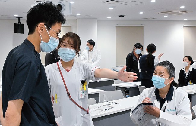 患者役とスタッフ役に分かれて実演する職員＝米子市西町、鳥取大医学部付属病院