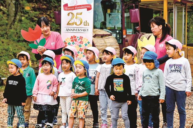 とっとり花回廊の開館25周年を祝い、童謡を合唱するひまわり保育園園児＝鳥取県南部町鶴田、とっとり花回廊