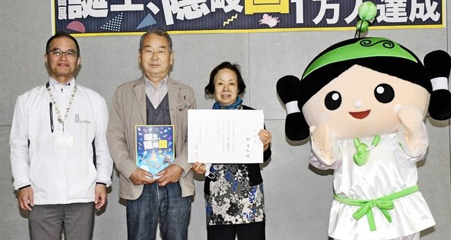 記念撮影に納まる林孝弘さん（左から２人目）と芳子さん（同３人目）＝出雲市大社町杵築東、島根県立古代出雲歴史博物館
