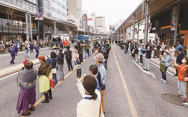 ＪＲ郡山駅前で行われた聖火リレーを、間隔を空けて見守る大勢の人たち＝３月、福島県郡山市