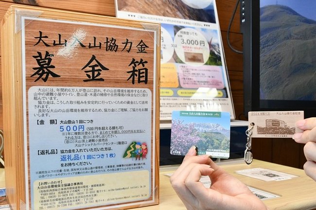 大山入山協力金の募金箱と返礼品＝鳥取県大山町大山、大山ナショナルパークセンター