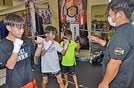 富村誠司会長の指導を受ける岩本操哉君（左から２人目）＝米子市二本木、米子ジム