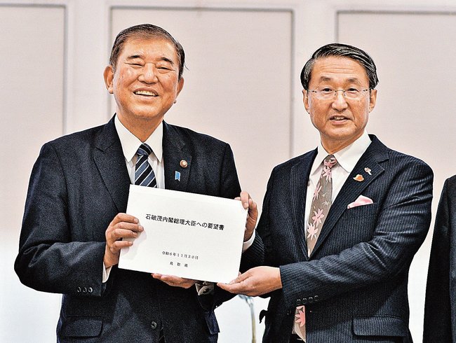 平井伸治知事（右）から要望書を受け取る石破茂首相＝鳥取市今町２丁目、ホテルニューオータニ鳥取