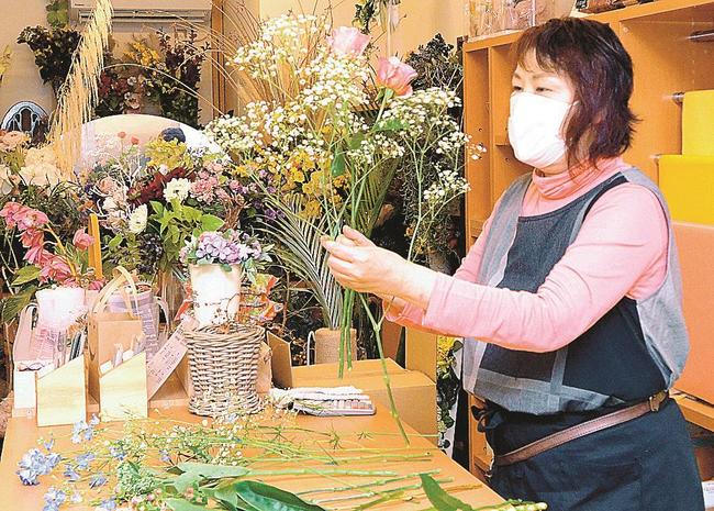 花を束ねる福間君枝さん＝大田市大田町、フラワーショップ福花園