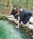 八重垣神社の鏡の池で「縁結び占い」をする観光客＝松江市佐草町