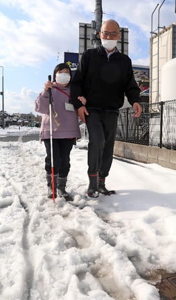点字ブロックがあるはずの歩道。清水かおりさん（左）が白杖をついて歩いたが、ほとんど分からなかった＝午後２時ごろ、松江市内