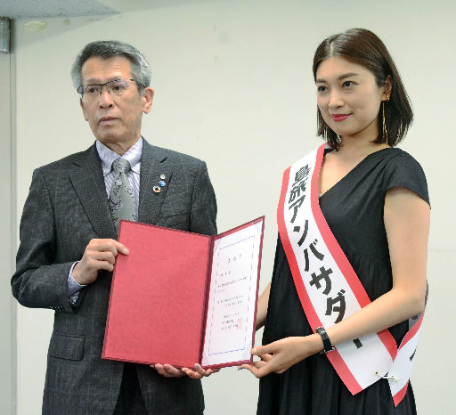 委嘱状を手渡す島の宝観光連盟の池田高世偉会長(左)と島旅アンバサダーに就任した小林希さん=東京都渋谷区、表参道・新潟館ネスパス