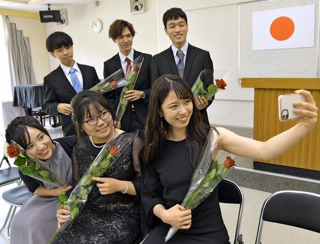 赤いバラの花を手に、記念撮影する新成人＝島根県吉賀町六日市、六日市体育館