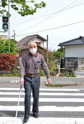 慎重に道路を横断する大道進一さん=境港市内
