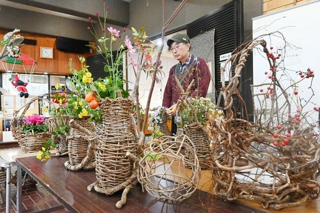 かずらで制作した花かごの作品を手入れする栗原哲朗さん＝松江市玉湯町玉造、出雲玉作資料館