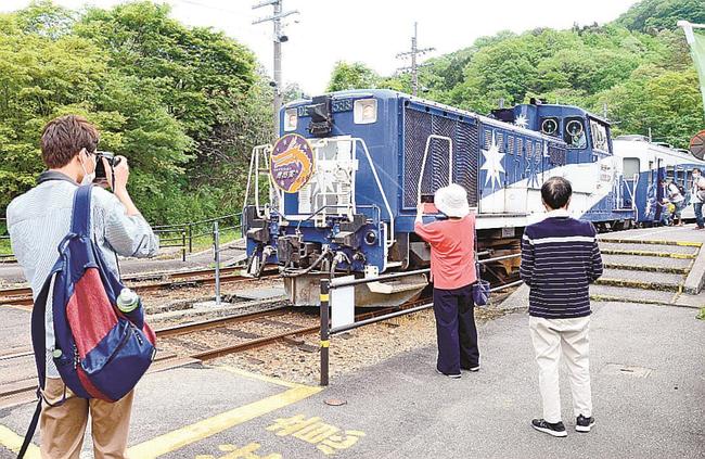 停車中の「奥出雲おろち号」の写真を撮る観光客＝１５日、島根県奥出雲町八川、ＪＲ出雲坂根駅
